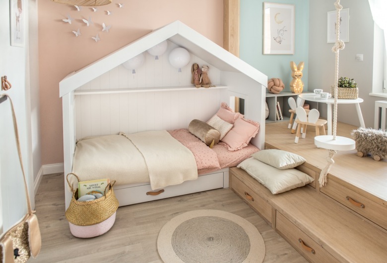W pokoju dziecięcym na podłodze znajdują się dębowe deski. Dzięki nim oraz innym drewnianym elementom jest tu ciepło i przytulnie. Białe łóżko w charakterystycznym kształcie domku dopełnia...