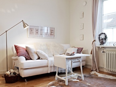 Biały składany stolik kawowy,srebrna lampa podłogowa i biała sofa w salonie (21926)