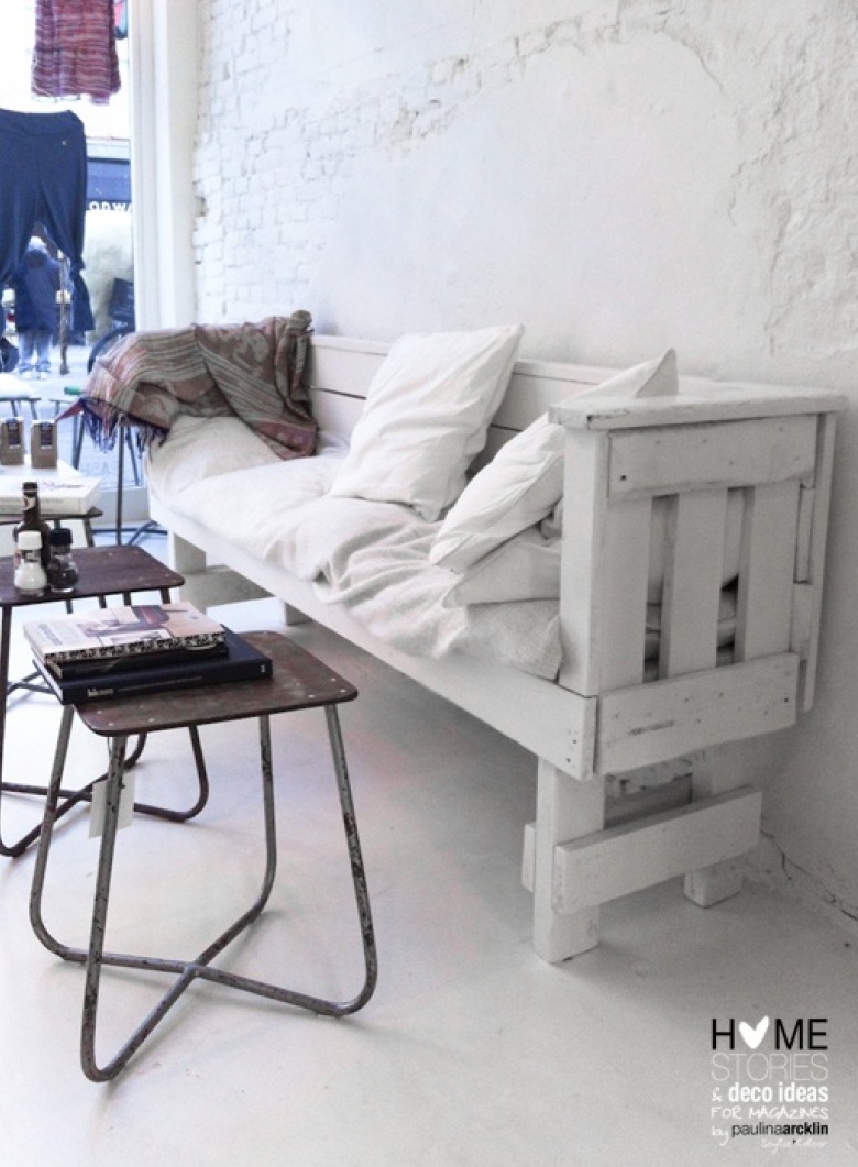 Biała ławka z drewnianej palety, industrialne stołki metalowe i biała cegła z patyna na ścianie (25327)