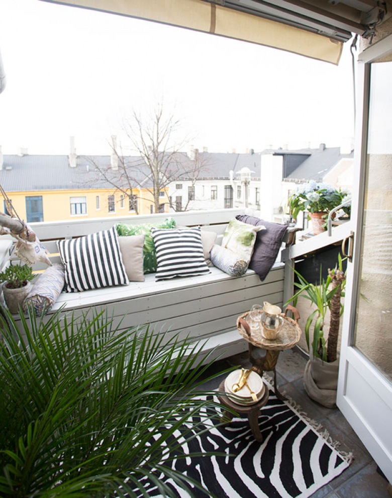 Aranżacja małego balkonu z drewnianą zabudową ze skrzynia i biało-czarnymi poduszkami (22925)