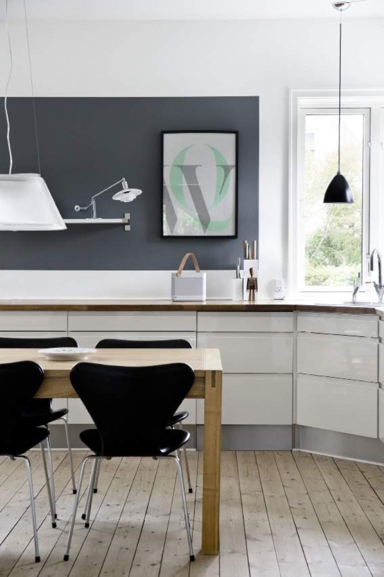 Biała kuchnia z czarną ścianą i krzesłami i drewniana naturalna podłoga z desek (21048)