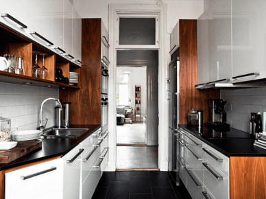 Drewniane boki szafek i czarne blaty w malej białej kuchni (21083)