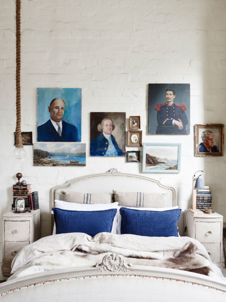 Klasyczne łóżko z niebieskimi poduszkami w sypialni w rustykalnym stylu (48315)
