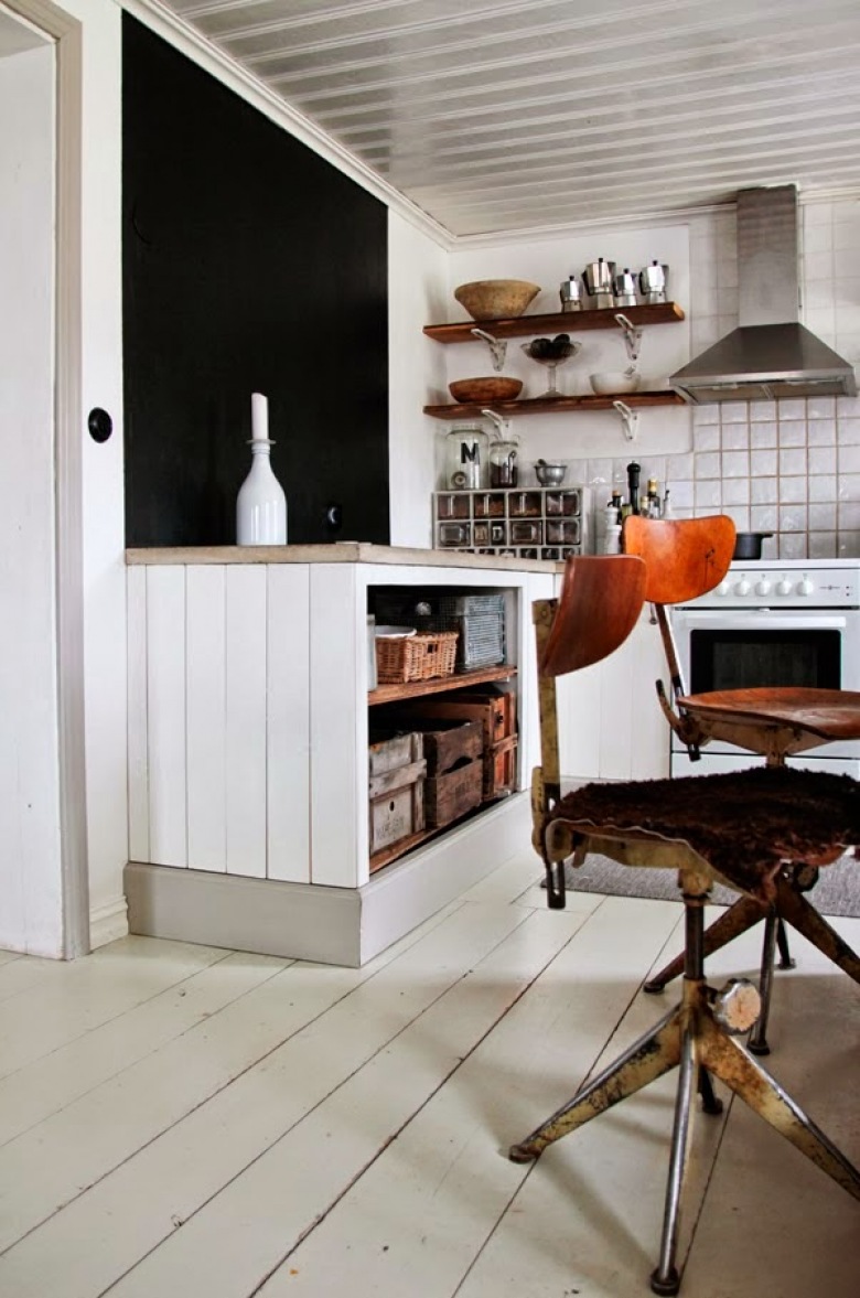 Otwarte białe szafki kuchenne  z drewnianymi blatami w stylu vintage,czarna ściana, drewniane półki i industrialne krzesła vintage (24823)