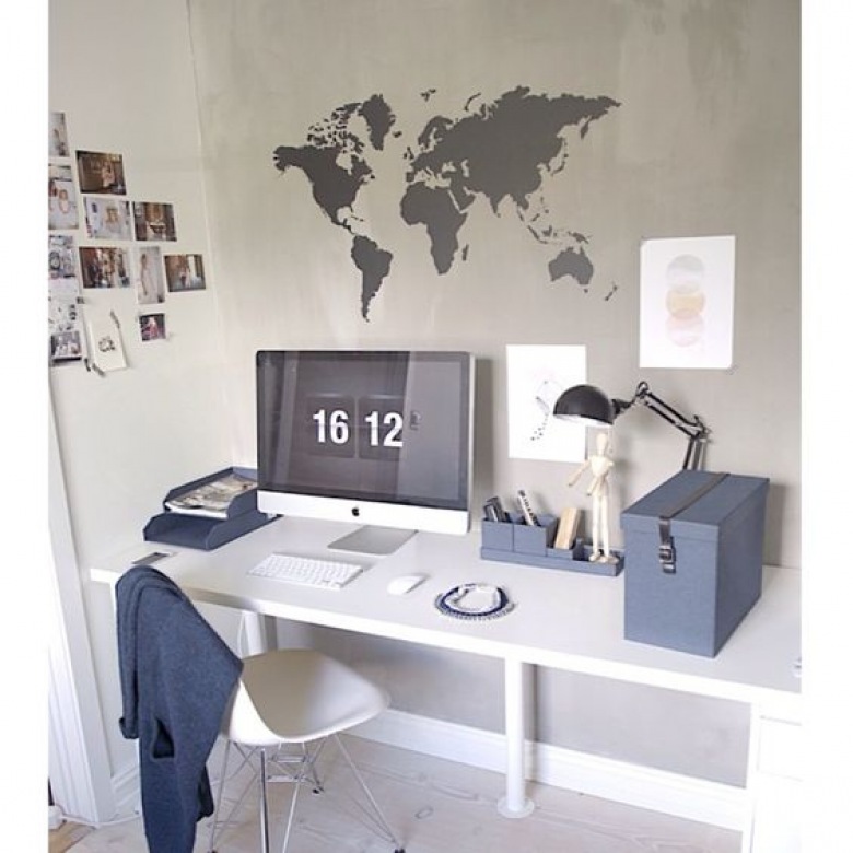 Na domowy gabinet składają się białe biurko i krzesło oraz ściana inspiracji. Wyklejona mapa świata może motywować do działania, a galeria fotografii po lewej stronie wnosi osobisty akcent do aranżacji....