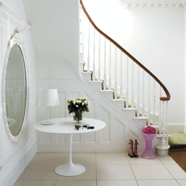 Owalne białe lustro,okragły stolik na jednej nodze i toczone białe tralki przy drewnianych schodach (22604)