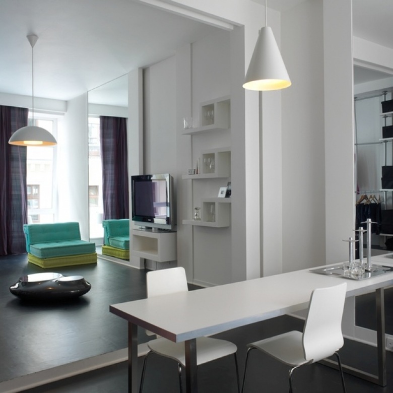 Biały nowoczesny salon z turkusowymi fotelami w otwartej zabudowie mieszkania (23677)