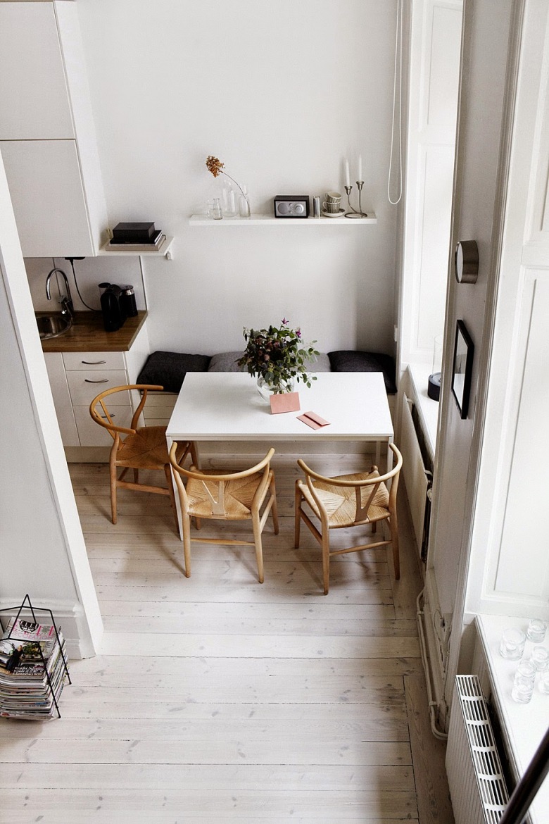 Biały nowoczesny stół w jadalni przy kuchni z zabudowanymi siedziskami i drewnianymi skandynawskimi krzesłami z plecioną jutą (27651)