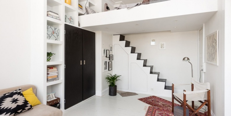 Biało-czarne schody  na antresole z łóżkiem  z wbudowanymi schowkami  w salonie  , czarna szafa wbudowana w ścianę z półkami (26089)