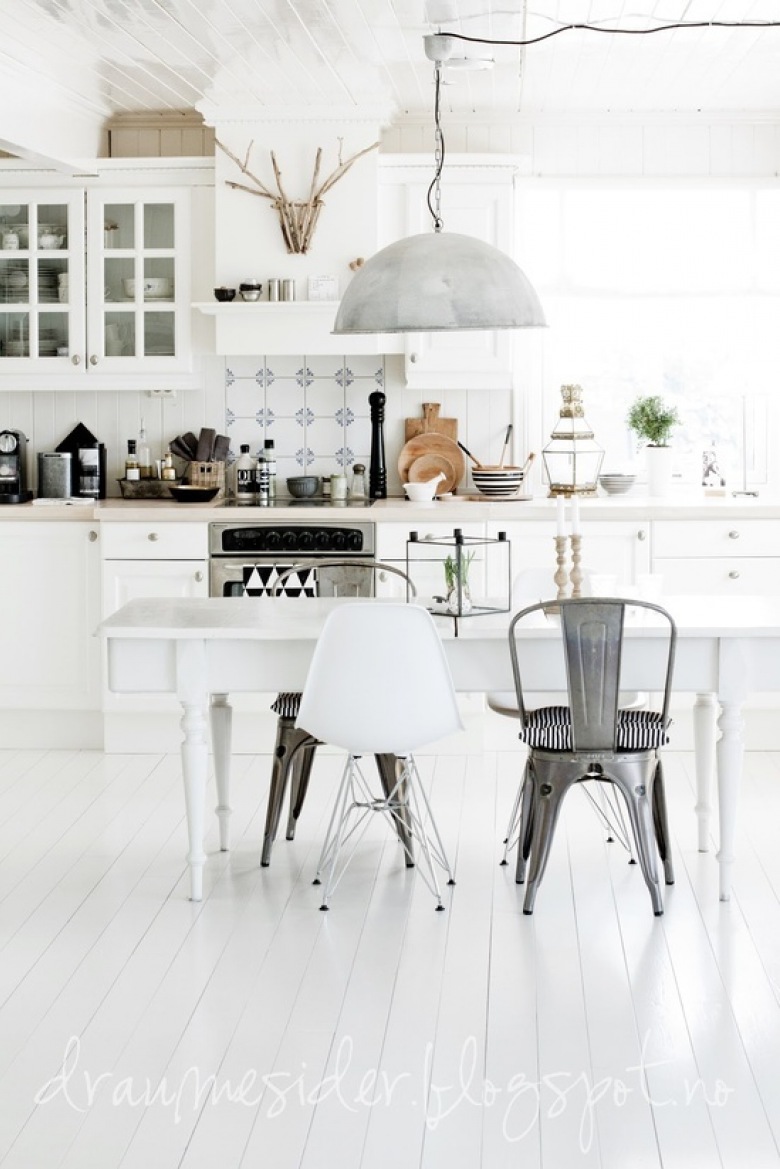 Tradycyjna biała kuchnia skandynawska z białym stołem na toczonych nogach,lampą z ocynku i mieszanymi krzesłami w stylu nowoczesnym i industrialnym (25241)