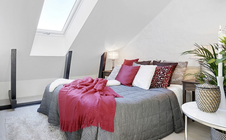 Biała sypialnia z szarą narzutą i różowymi poduszkami i pledem (21833)