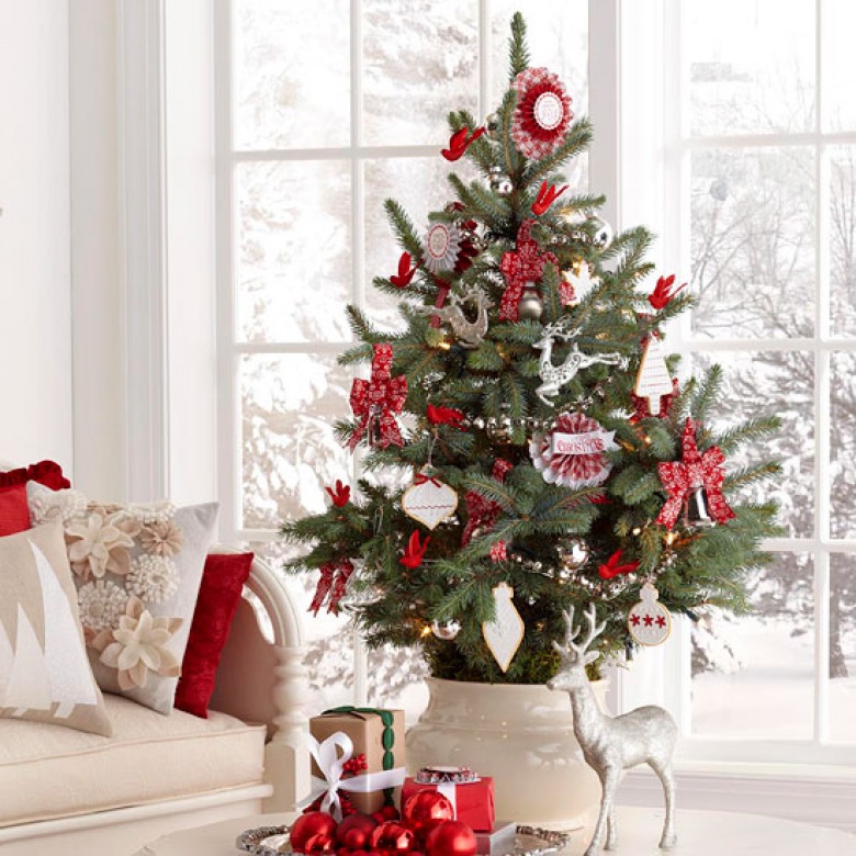 Biało-czerwone dekoracje świąteczne i mała choinka w ceramicznym wazonie na stole (27181)