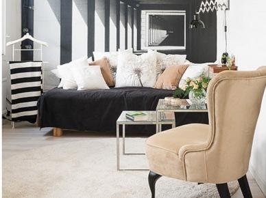 Karmelowy fotel uszak i karmelowe poduszki na czarnej sofie w salonie z czarno-białą fototapetą na ścianie (26260)