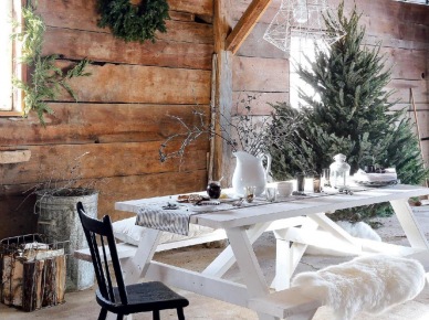 Białe druciane lampy nad malowanym białym stołem na kozłach z ławką,zielone girlandy i wianki z igliwia w aranzacji zimowego świątecznego tarasu (27341)