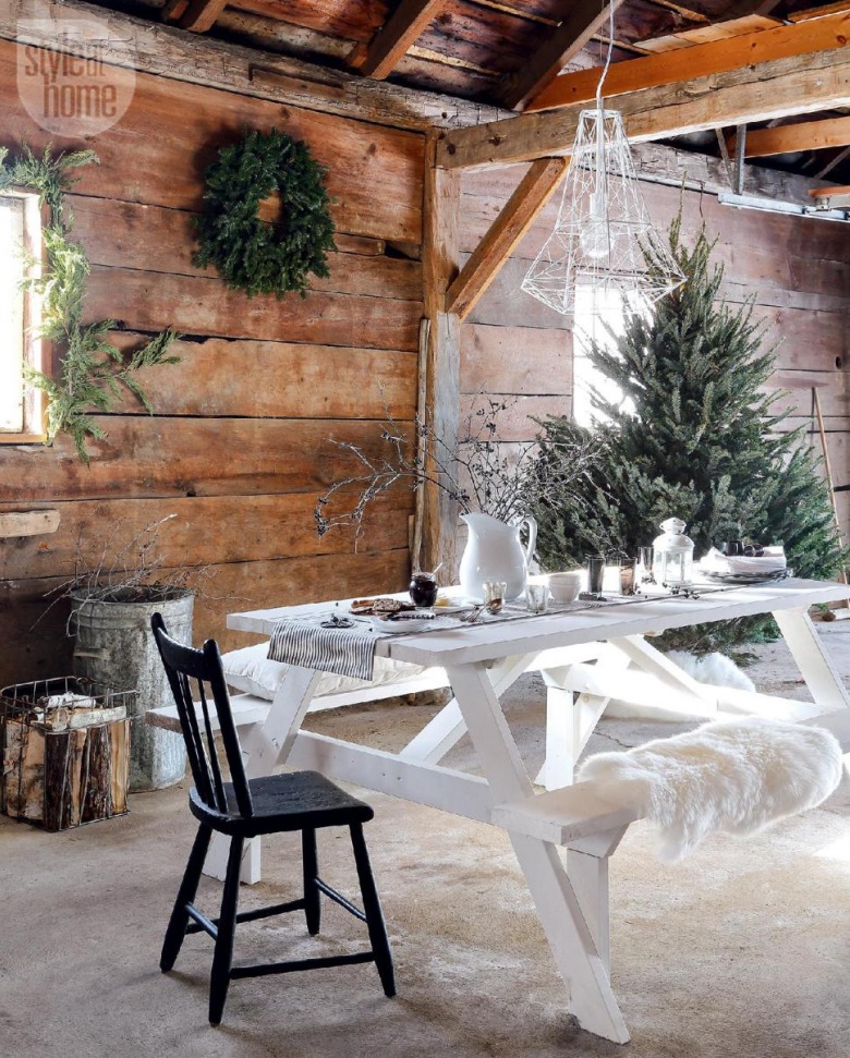 Białe druciane lampy nad malowanym białym stołem na kozłach z ławką,zielone girlandy i wianki z igliwia w aranzacji zimowego świątecznego tarasu (27341)