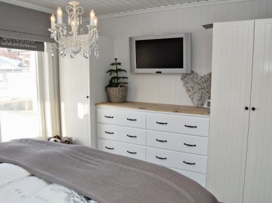 Żyrandol, białe szafy z komodami w sypialni w stylu skandynawskim (23880)
