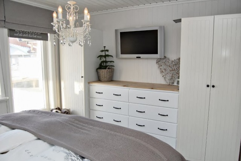 Żyrandol, białe szafy z komodami w sypialni w stylu skandynawskim (23880)