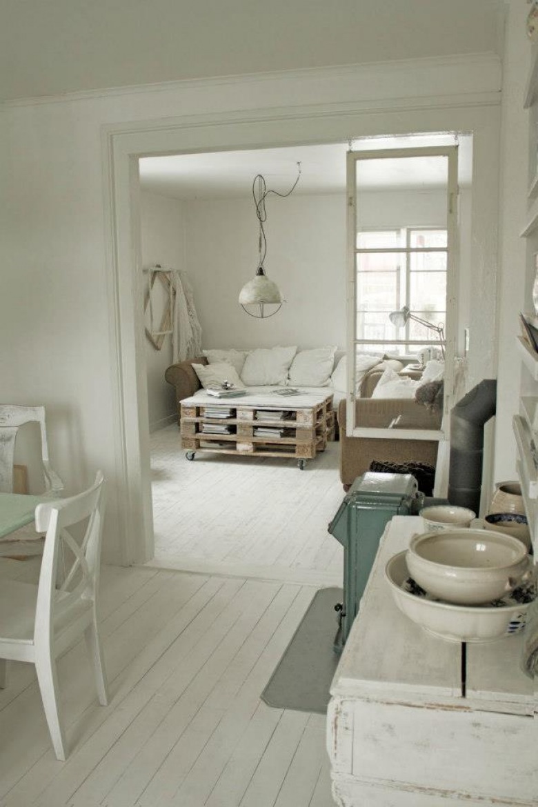 Biały salon ze stolikiem z palety, industrialna lampą i białą podłogą (20576)