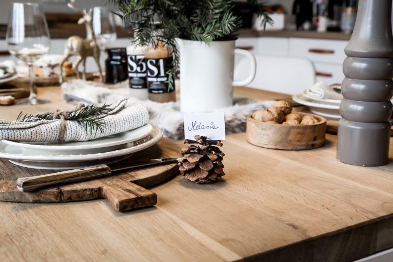Na stole stoi sporo drewnianych dodatków, które z wdziękiem nawiązują do blatu. Podkreślają też prostotę i naturalność świątecznej...