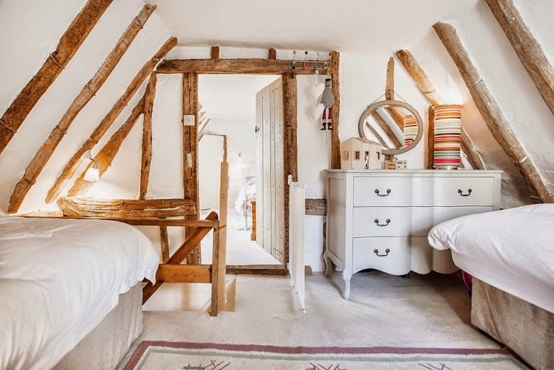 Sypialnia dla gości na poddaszu z drewnianymi belkami,okrągłym lustrem i francuska komodą (24934)