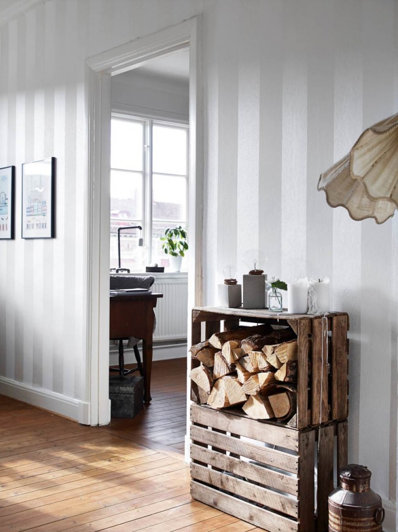 Podłoga z desek,drewniane skrzynki z drewnem i szaro-biała tapeta w pasy szerokie na ścianie (27106)