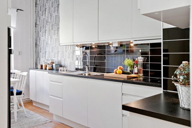 Graficzna tapeta ścienna, czarne płytki cegiełki w kuchni skandynawskiej z białymi szafkami i czarnymi blatami (28488)