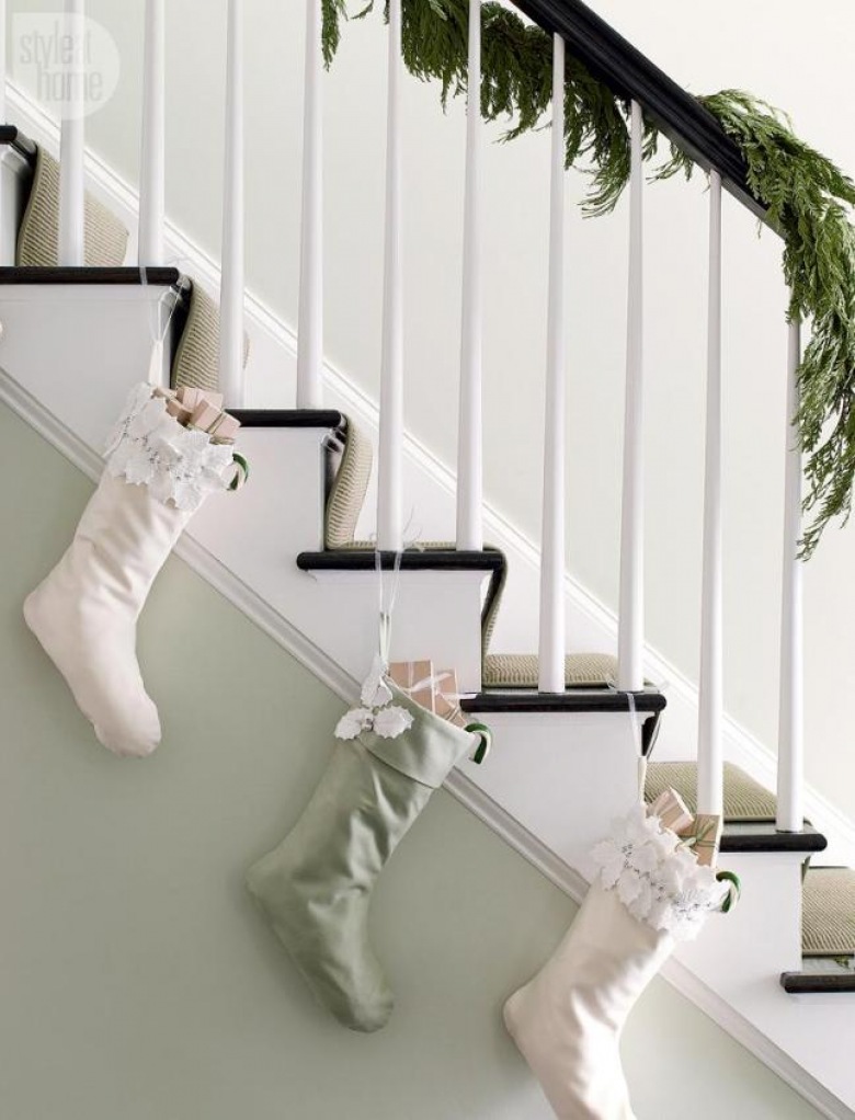 Białe schody z czarnymi stopnicami w świątecznej dekoracji z igliwia i biało-miętowych bożonarodzeniowych skarpet (27166)