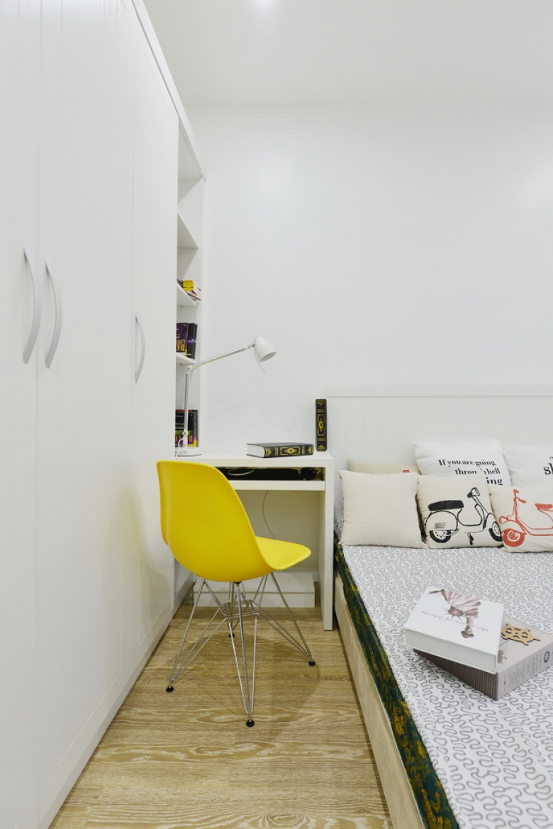 Biała zabudowa szaf i żółte krzesło na metalowych krzyżakach w aranżacji nowoczesnej sypialni (25091)