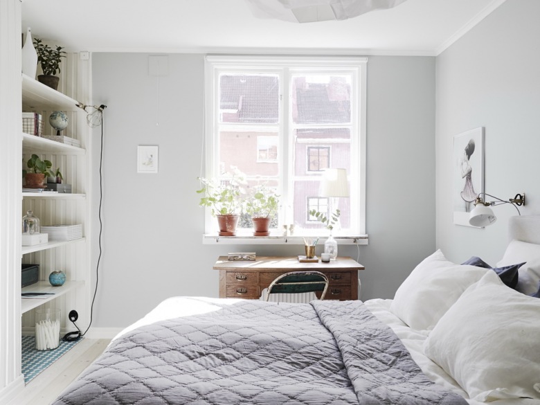 Szaro-liliowa narzuta pikowana na łóżku w sypialni z wnęką ścienną z półkami,drewniane biurko pod oknem (26528)