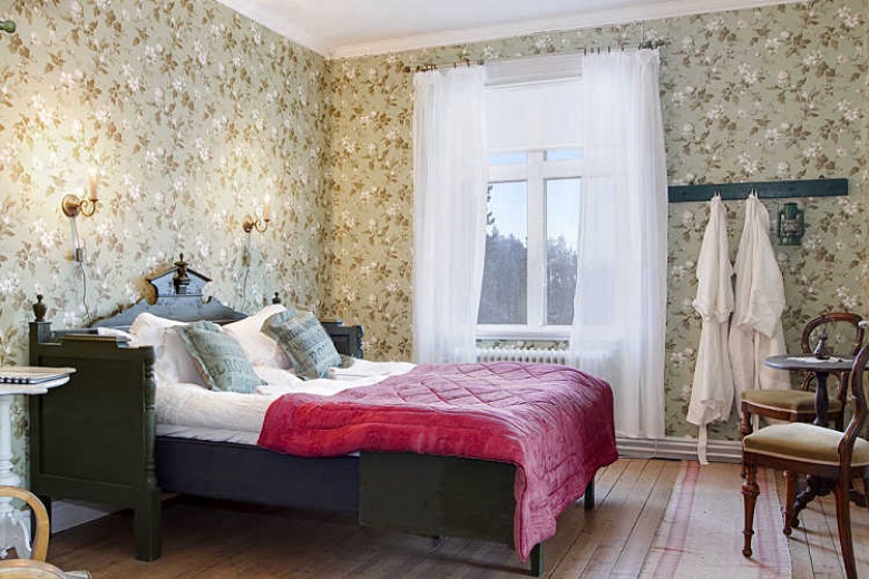 Tapeta w kwiaty,stylowe drewniane łóżko i białe firanki w eklektycznej sypialni (27640)