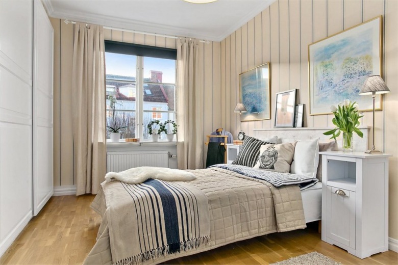 Biało-beżowa sypialnia skandynawska z granatowymi dodatkami na łóżku (27688)