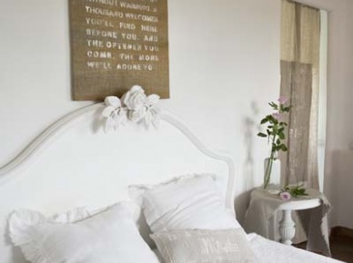 Białe rzeźbione łóżko w sypialni z drewnianymi belkami (22195)