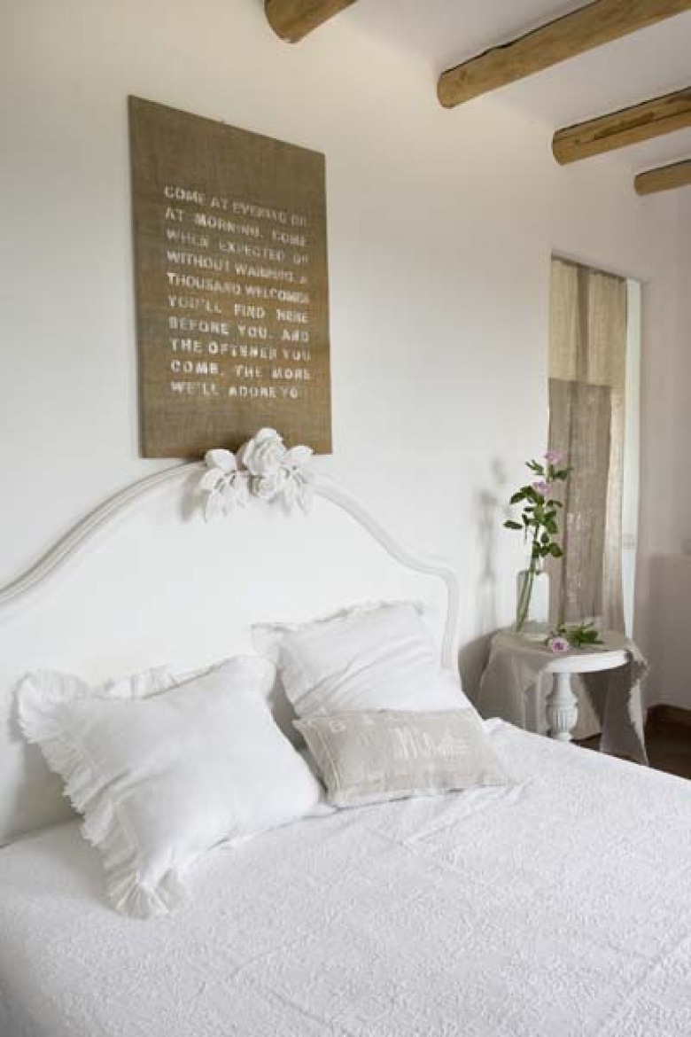 Białe rzeźbione łóżko w sypialni z drewnianymi belkami (22195)