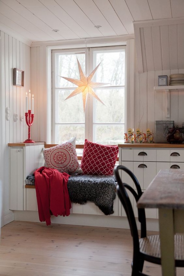 Zabudowę kuchenną dostosowano do wysokiego okna. Umiejscowiona tuż pod nim leżanka wnosi wiele ciepła do wnętrza. Kolory bieli i czerwieni dodają jej świątecznego...
