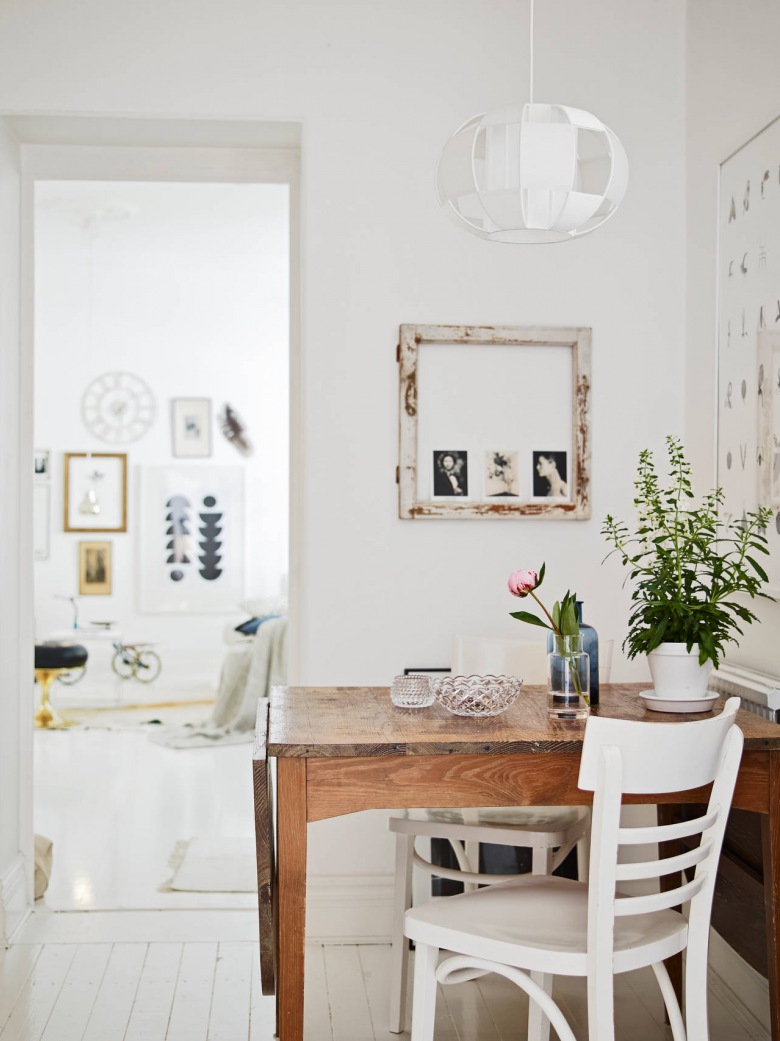 Nowoczesna ażurowa lampa nad drewnianym stołem w jadalni,białe tradycyjne krzesła i ramki vintage na ścianie (24721)