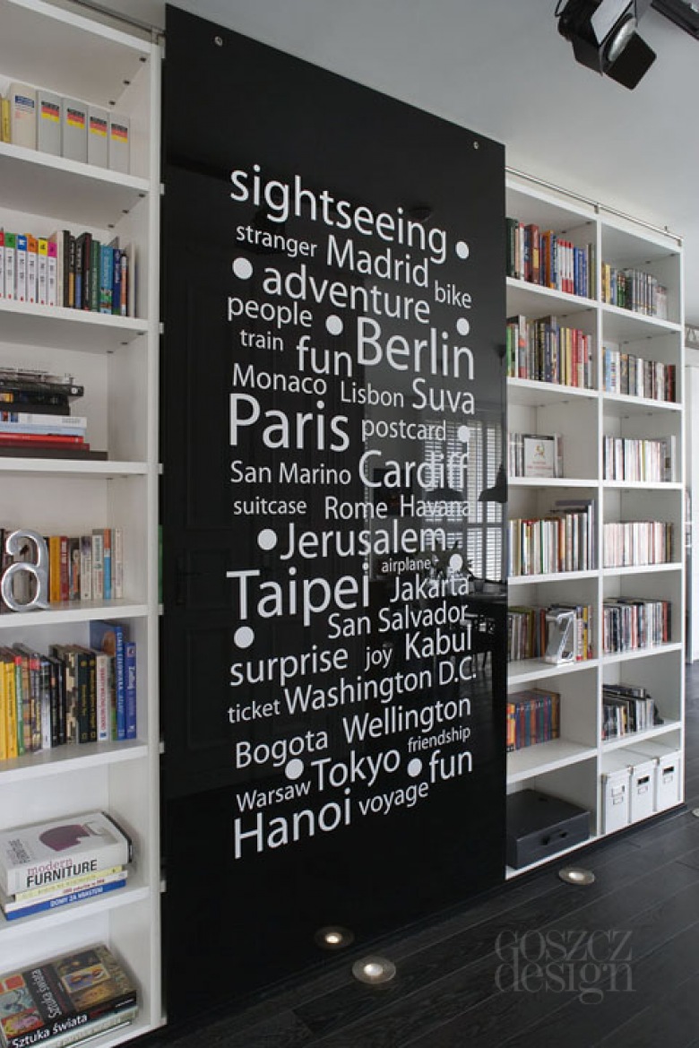 Szklane czarne ścianki przesuwane z  białą typografią przy domowej biblioteczce (24116)