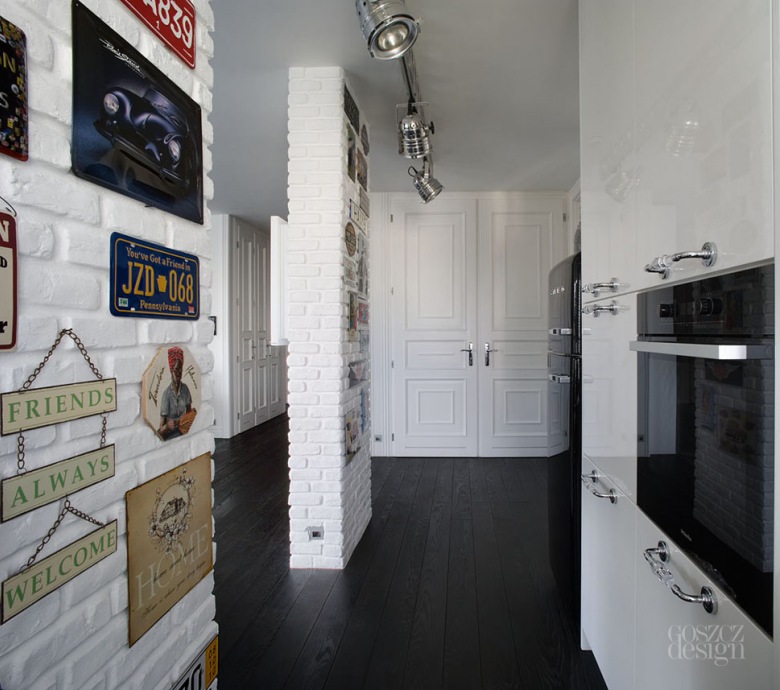 Biała lakierowana kuchnia ze ścianami z białej cegły i galerią metalowych tabliczek w stylu retro i vintage (24113)