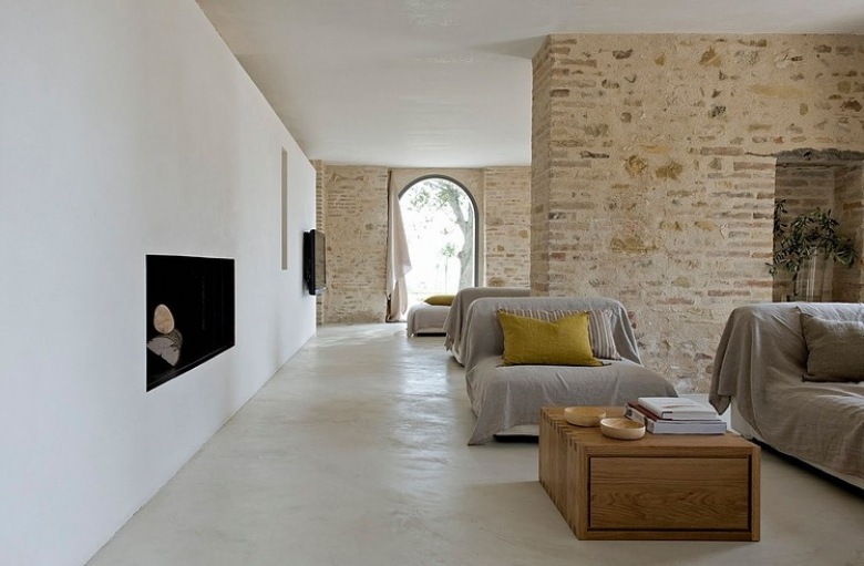 Otwaty salon z kamiennymi ścianami i nowoczesnym kominkiem wbudowanym w białą ścianę (23387)