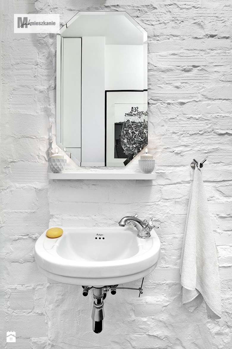 Niezwykle prosta i jasna łazienka. Jako tło do nowoczesnych akcentów, takich jak proste lustro, umywalka czy uchwyt na ręcznik, wykorzystano ścianę z pomalowanych na biało...