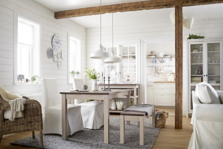 Biała kuchnia z jadalnią z krzesłami w bialych ubrankach, z ławką i wiklinowym fotelem (24871)