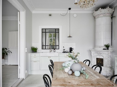 Wewnętrzne metalowe okno w małej kuchni z ceramicznym piecem skandynawskim,postarzany bielony stół z drewna z czarnymi gietymi krzesłami (47749)