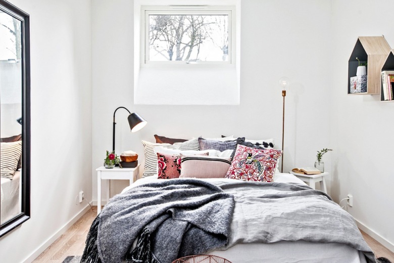 Prostokątne czarne lustro na ścianie w białej sypialni z różowymi poduszkami (28085)