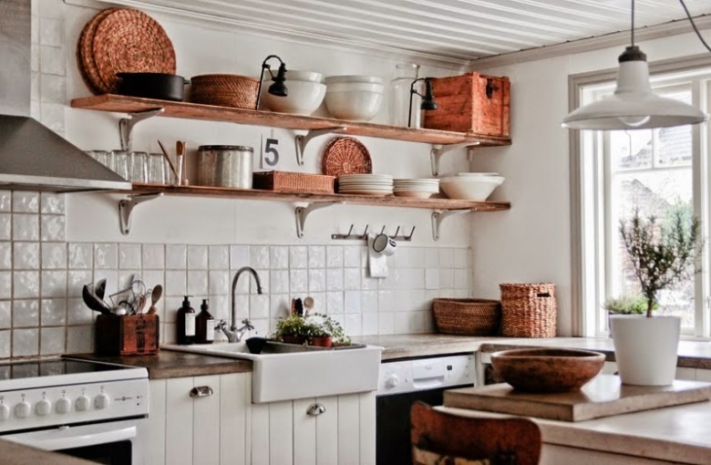 Biała kuchnia rustykalna z drewnianymi półkami na ścianie,miedzianymi naczyniami,wiklinowymi i drewnianymi dekoracjami (24820)