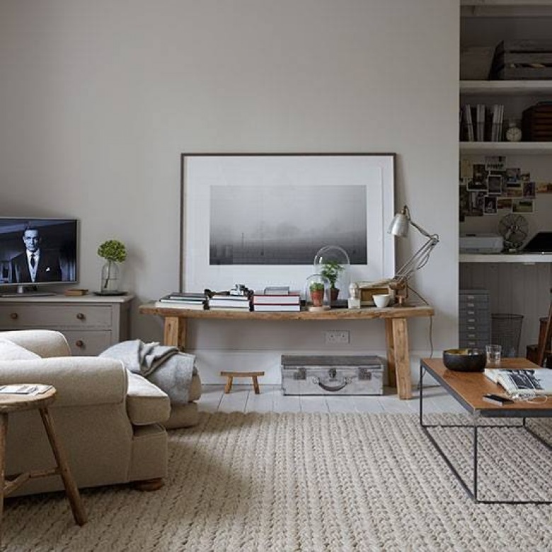 Tkany dywan,industrialny stolik,drewniana ławka z grafiką w ramach i wnęka z pólkami w salonie skandynawskim (27438)