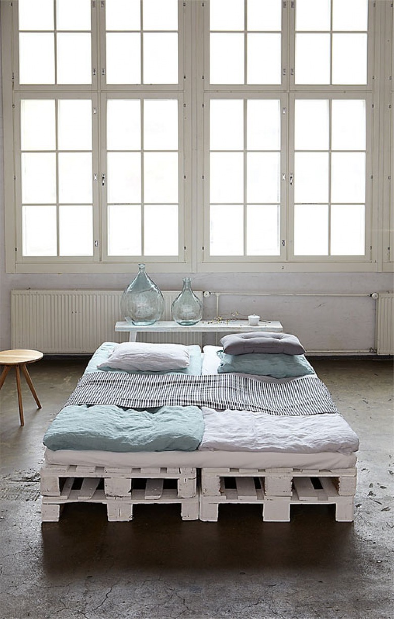 Pomalowane na biało palety w roli  bazy łóżka  w aranżacji  sypialni w industrialnym stylu (22093)