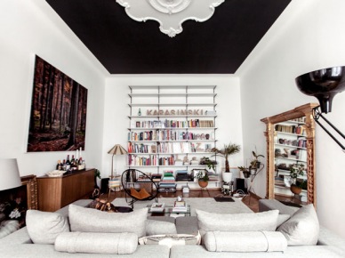 Czarny sufit z białymi ornamentem ze sztukaterii,rzeźbione lustro,nowoczesna biala sofa,i  drewniana komoda w eklektycznym salonie (25581)