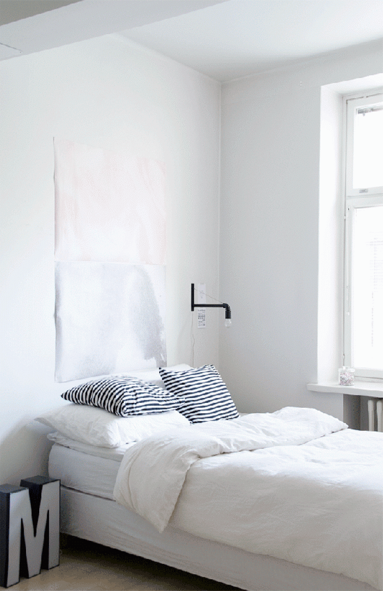 Biała sypialnia w minimalistycznym skandynawskim stylu z industrialnym kinkietem i szarą literą 3d (25718)