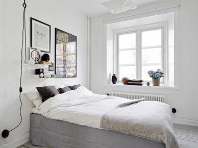 Żarówka na kablu,papierowy abażur na wiszącej lampie,nowoczesne grafiki na ścianie i biało-szara dekoracja łóżka z czarnymi poduszkami (24879)