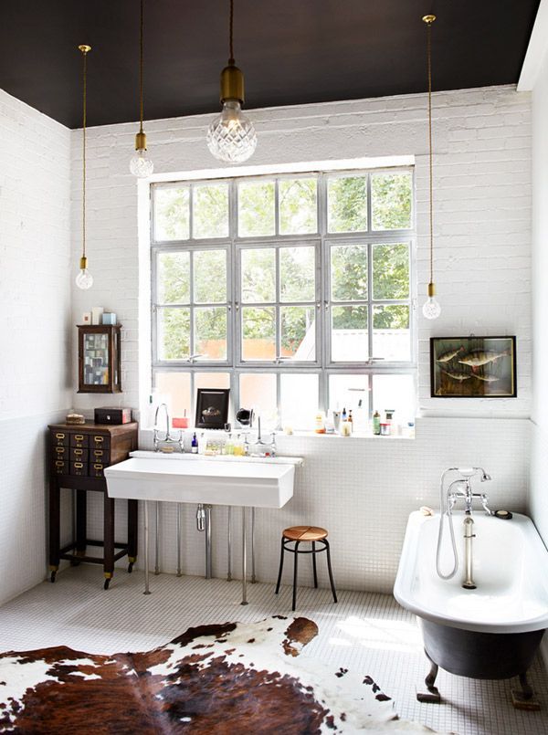 Wysoka łazienka z białymi cegłami oraz kontrastowo dobranymi czarnymi elementami, w tym jednym najbardziej efektownym -...