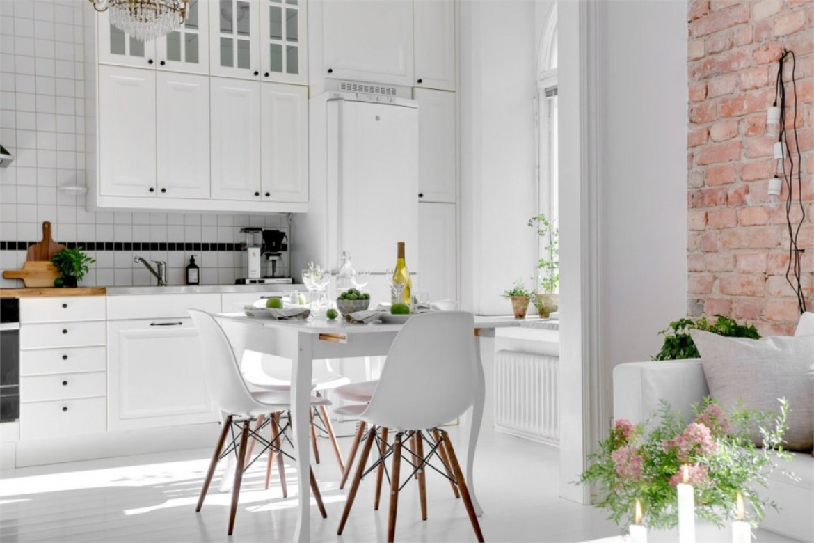 Biała kuchnia skandynawska z kwadratowymi płykami na ścianie,białym stołem i ścianą z czerwonej cegły (28156)